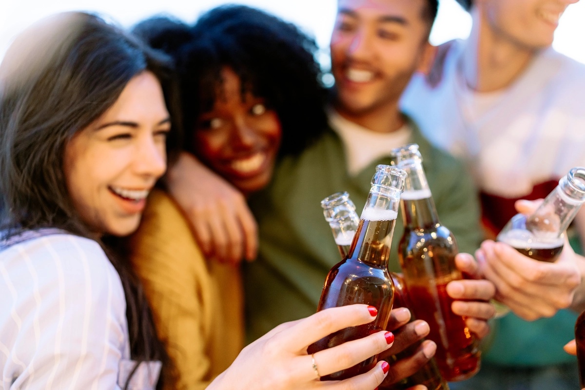 Alcohol Addiction: Friends cheering with drinks in hands