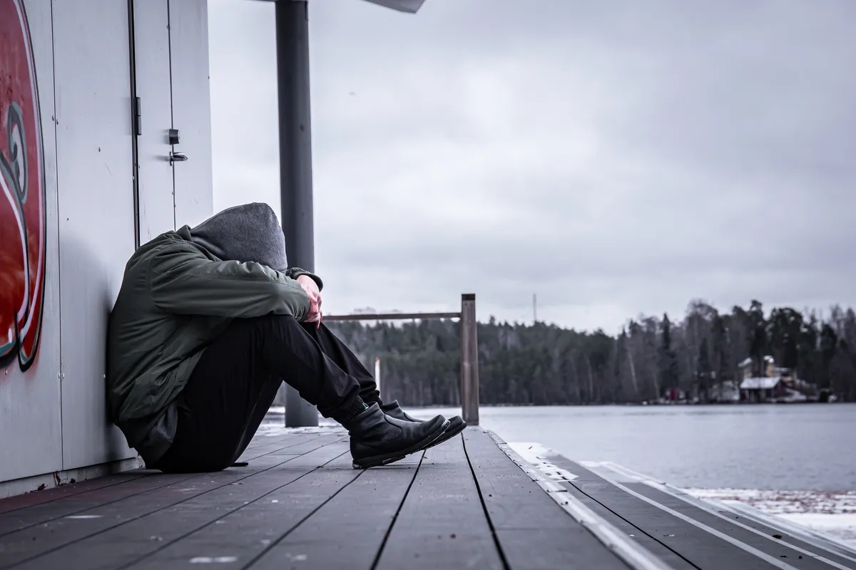 Inhalant Addiction: Man sitting on a dock with his face between his knees