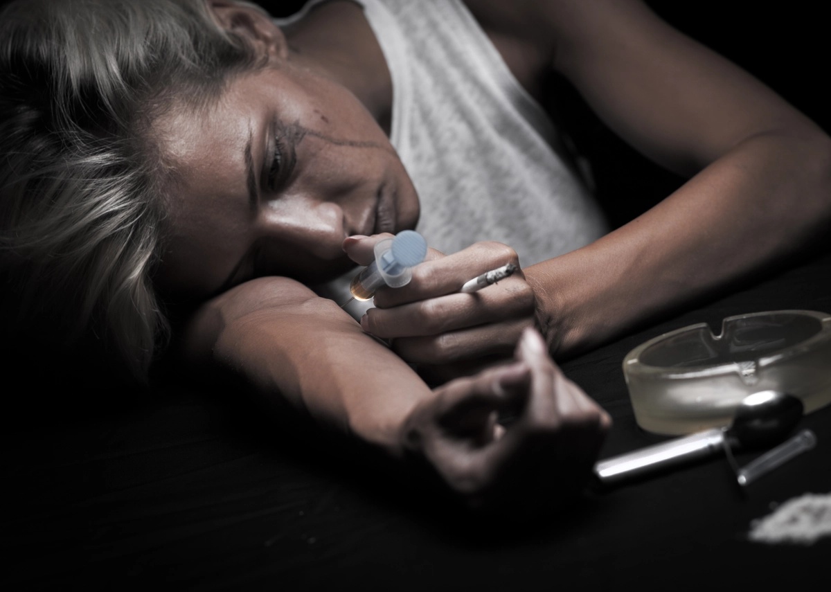 Cocaine Addiction: Woman staring at a needle near her arm