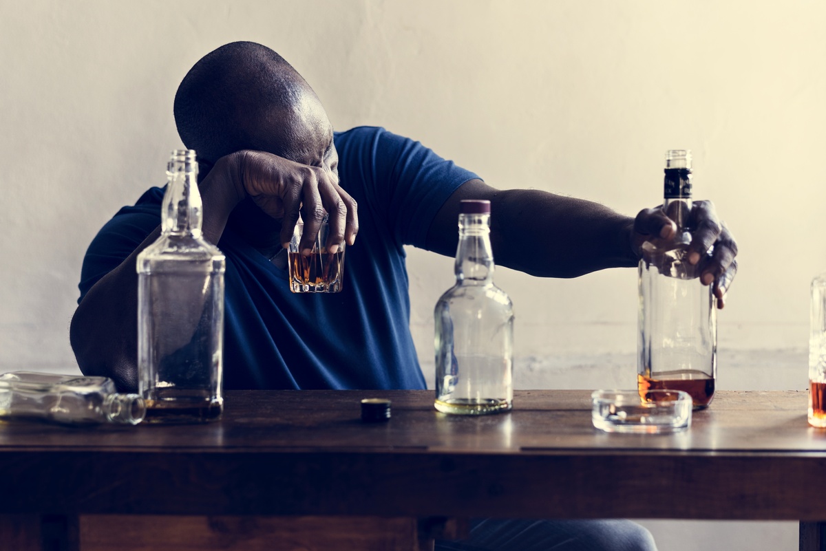 Alcohol Addiction: Man in despair drinking at a bar