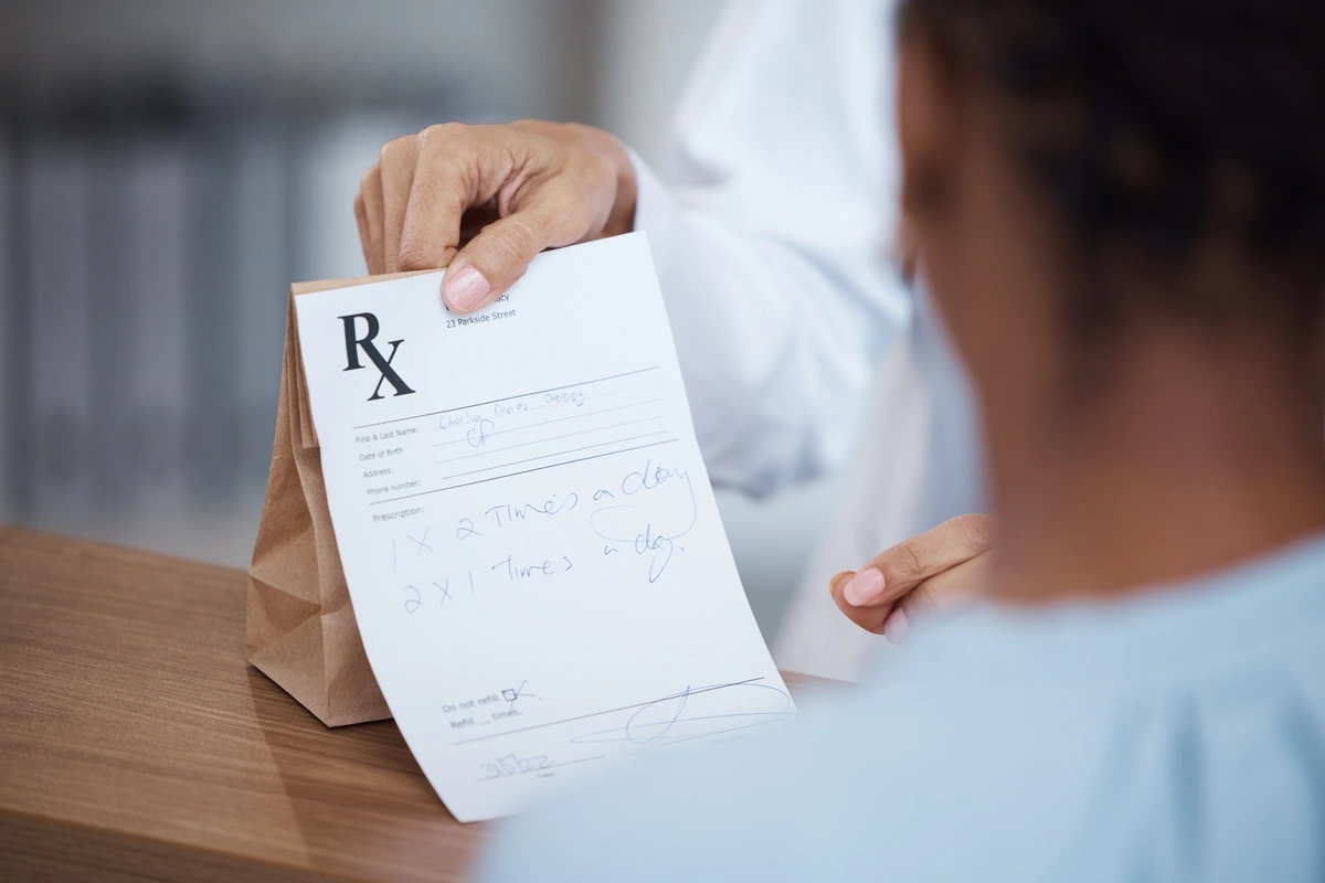 Prescription Drug Addiction: Pharmacist handing over a prescription to patient
